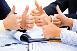 Three people holding their thumbs up meaning a great business plan